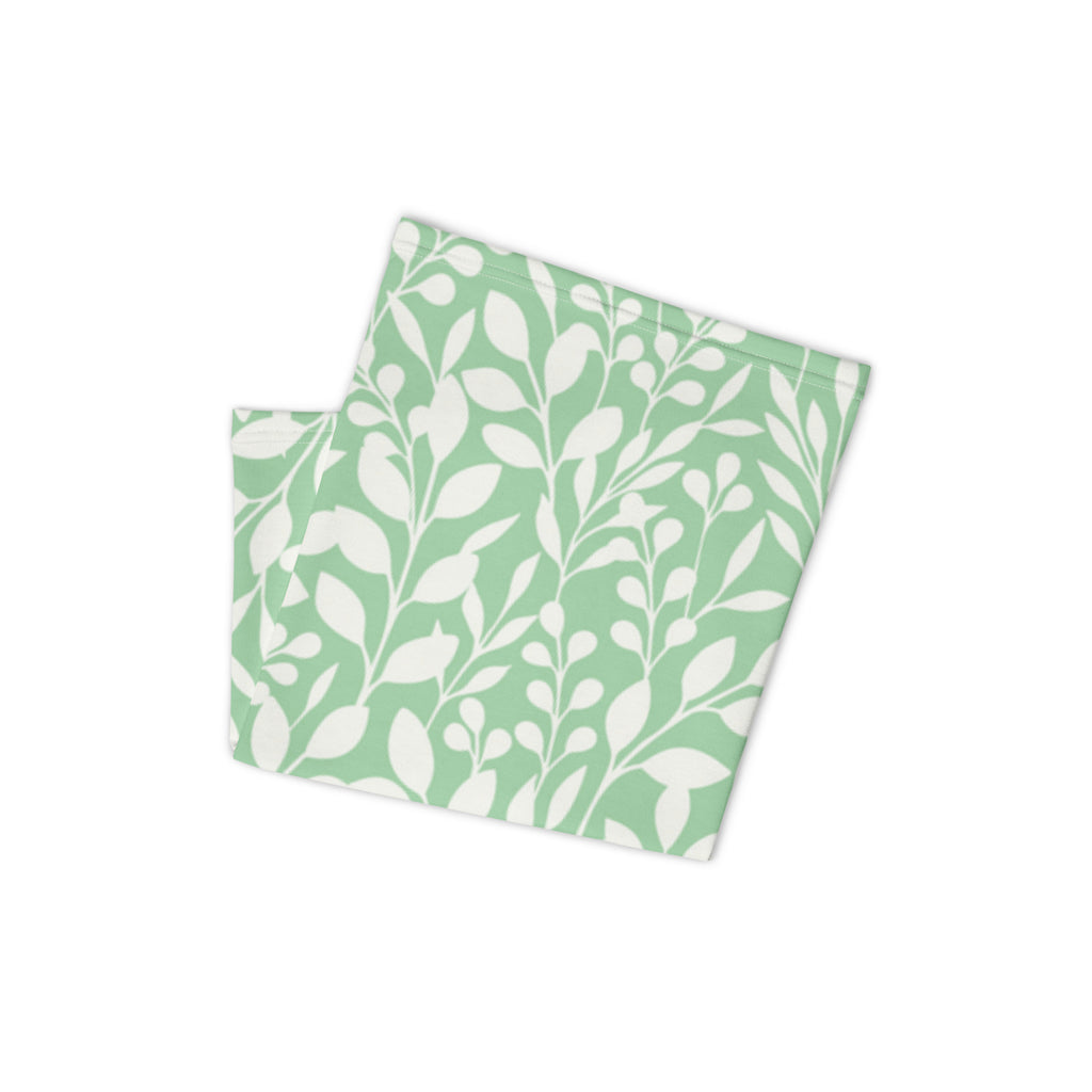 Folded mint green Casting Queens fishing neck gaiter featuring white floral pattern design, lightweight women’s fishing apparel accessory for sun protection and outdoor adventures.