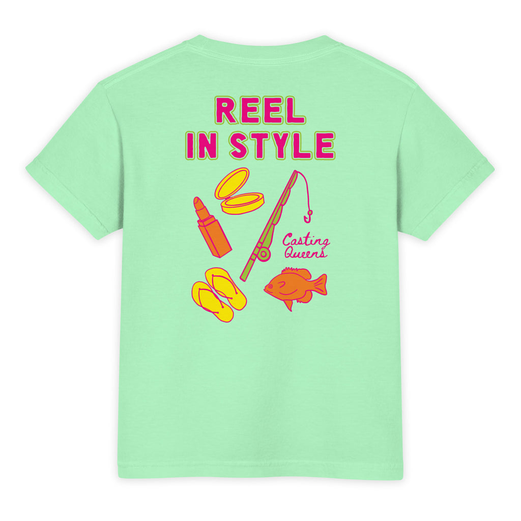 Mint green youth fishing t-shirt featuring bold colorful Reel In Style graphics with fishing gear, flip flops, makeup compact, and retro lake life artwork on the back.